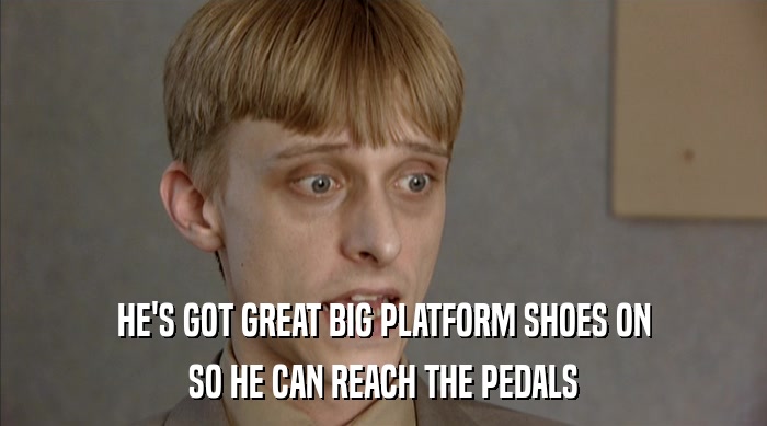 HE'S GOT GREAT BIG PLATFORM SHOES ON SO HE CAN REACH THE PEDALS 
