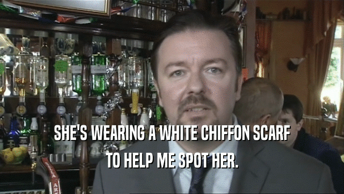 SHE'S WEARING A WHITE CHIFFON SCARF TO HELP ME SPOT HER. 