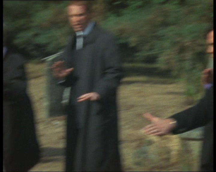 PRIEST INTONES A PRAYER  