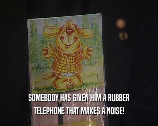 SOMEBODY HAS GIVEN HIM A RUBBER TELEPHONE THAT MAKES A NOISE! 