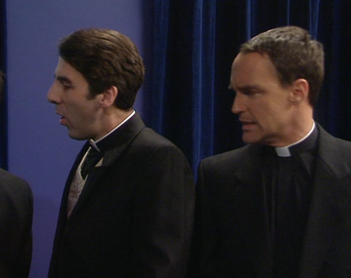 (AMERICAN ACCENT) WHO'S THE SILVER-HAIRED PRIEST? 
