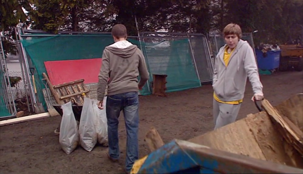 FREEZING HIS ARSE OFF AT A DISGUSTING PLANT-HIRE YARD. 