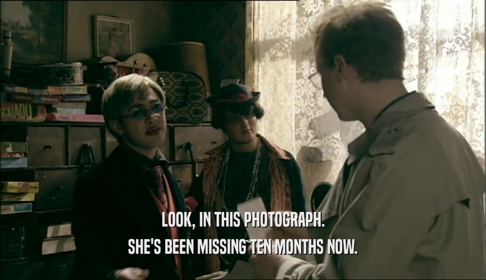 LOOK, IN THIS PHOTOGRAPH. SHE'S BEEN MISSING TEN MONTHS NOW. 