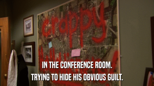 IN THE CONFERENCE ROOM. TRYING TO HIDE HIS OBVIOUS GUILT. 