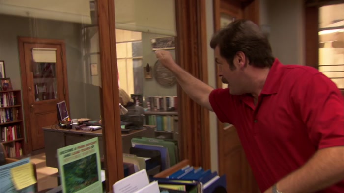 HE WEARS A RED SHIRT AND BLACK PANTS. 
