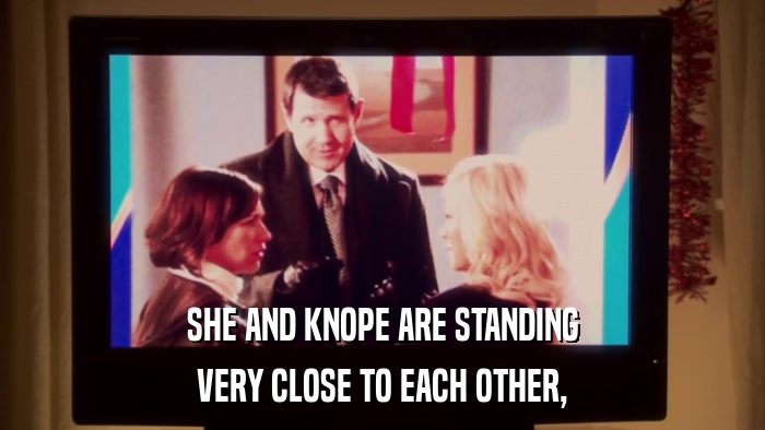 SHE AND KNOPE ARE STANDING VERY CLOSE TO EACH OTHER, 