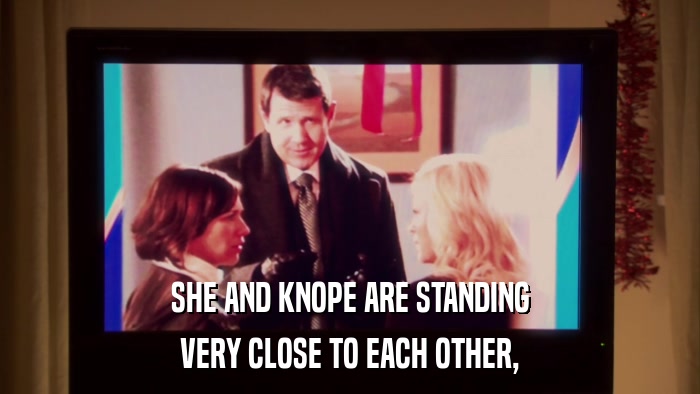 SHE AND KNOPE ARE STANDING VERY CLOSE TO EACH OTHER, 