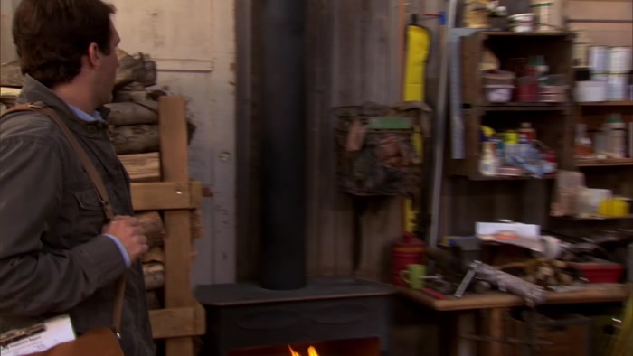 THERE IS A BASKET OF OIL-SOAKED RAGS ABOVE A WOOD-BURNING STOVE. 