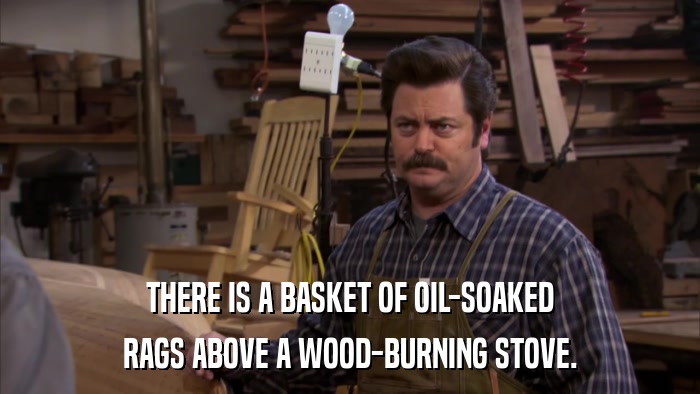THERE IS A BASKET OF OIL-SOAKED RAGS ABOVE A WOOD-BURNING STOVE. 