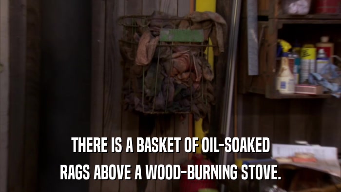 THERE IS A BASKET OF OIL-SOAKED RAGS ABOVE A WOOD-BURNING STOVE. 