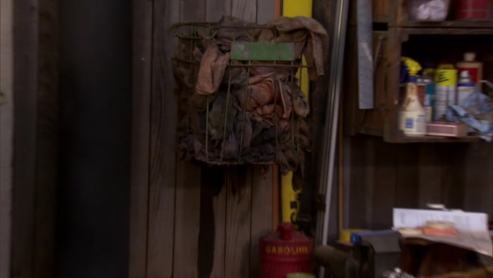 THERE IS A BASKET OF OIL-SOAKED RAGS ABOVE A WOOD-BURNING STOVE. 