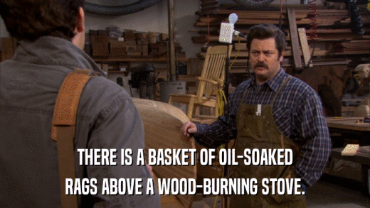 THERE IS A BASKET OF OIL-SOAKED RAGS ABOVE A WOOD-BURNING STOVE. 