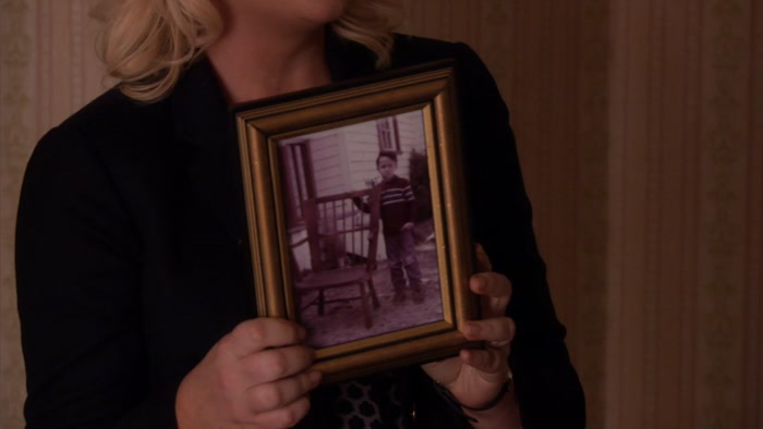 HE'S STANDING NEXT TO THE FIRST CHAIR 