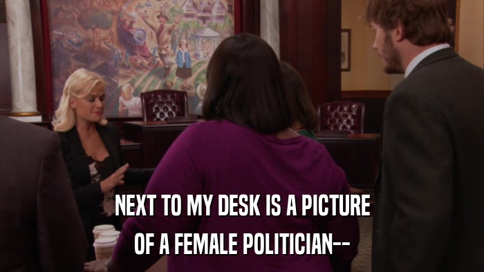 NEXT TO MY DESK IS A PICTURE OF A FEMALE POLITICIAN-- 