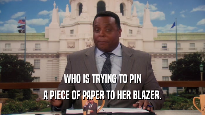 WHO IS TRYING TO PIN A PIECE OF PAPER TO HER BLAZER. 