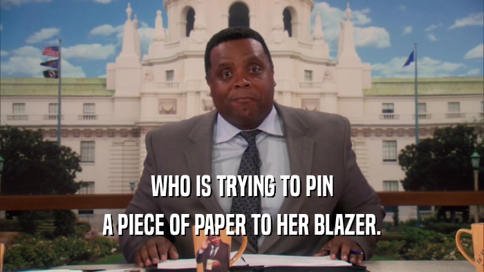 WHO IS TRYING TO PIN A PIECE OF PAPER TO HER BLAZER. 