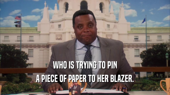 WHO IS TRYING TO PIN A PIECE OF PAPER TO HER BLAZER. 