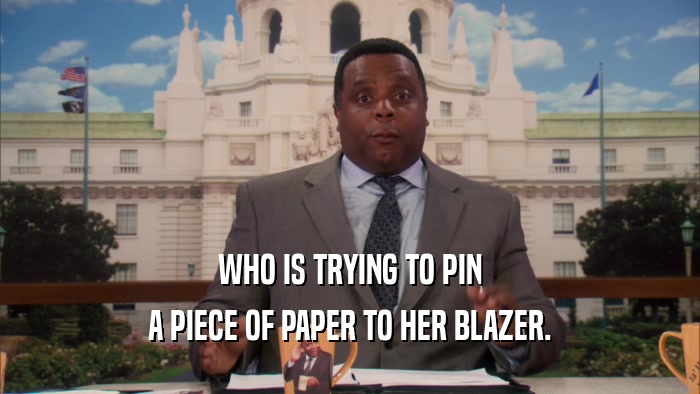 WHO IS TRYING TO PIN A PIECE OF PAPER TO HER BLAZER. 