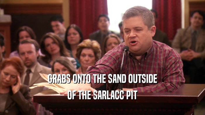 GRABS ONTO THE SAND OUTSIDE OF THE SARLACC PIT 