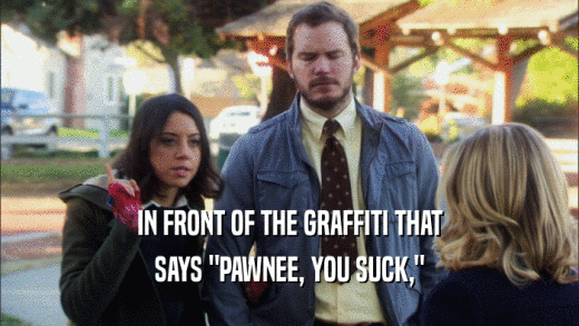 IN FRONT OF THE GRAFFITI THAT SAYS 