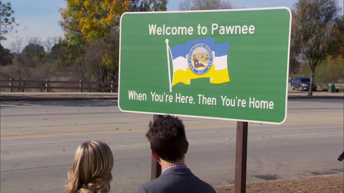 THE WRONG WAY AND IT'S WELCOMING YOU TO PAWNEE AS YOU'RE LEAVING. 