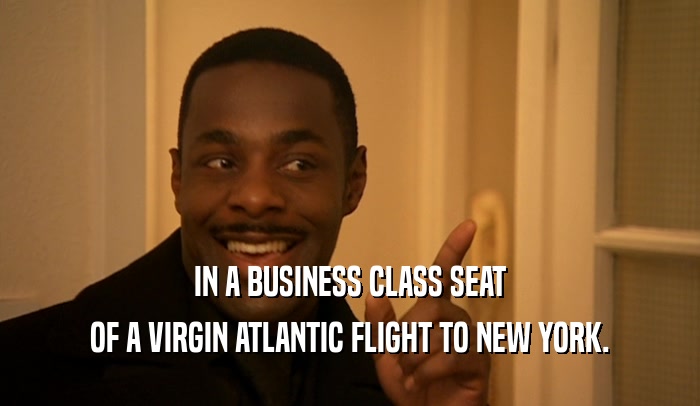 IN A BUSINESS CLASS SEAT OF A VIRGIN ATLANTIC FLIGHT TO NEW YORK. 