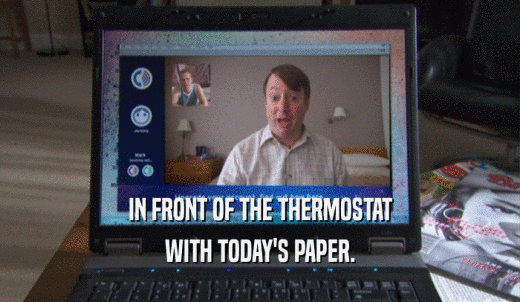 IN FRONT OF THE THERMOSTAT WITH TODAY'S PAPER. 