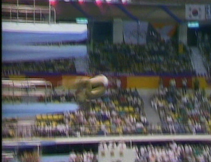 GREG LOUGANIS. DOWN,
 DOUBLE BACK-TWISTER, BANGS HIS HEAD AND IN.
 
