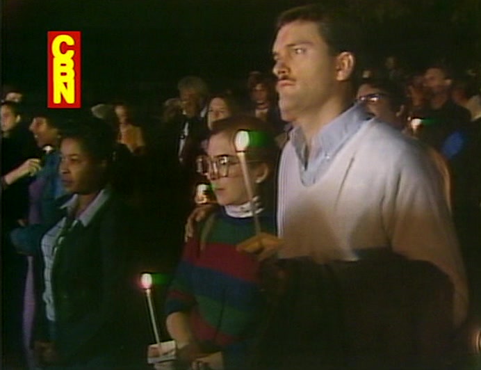 PRESS AND PROTESTERS CONDUCT A SILENT VIGIL OUTSIDE THIS DISGRACELAND. 