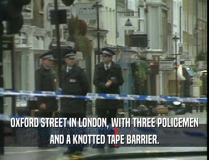 OXFORD STREET IN LONDON, WITH THREE POLICEMEN
 AND A KNOTTED TAPE BARRIER.
 