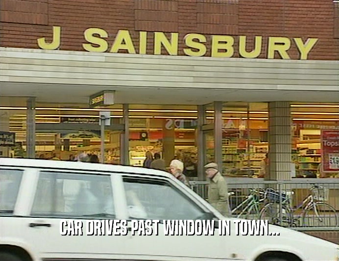 CAR DRIVES PAST WINDOW IN TOWN...
  